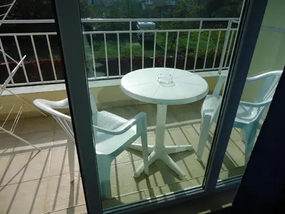 a white table and two chairs on a balcony at Pension RUSKOVI GuestHouse in Ravda