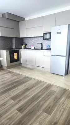 a kitchen with white cabinets and a white refrigerator at Sarafovo Resort Deluxe in Burgas City