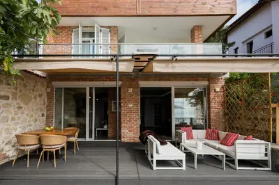 a patio with white furniture and a table and chairs at Villa Alenor | Sea View & Beach Access in Nesebar