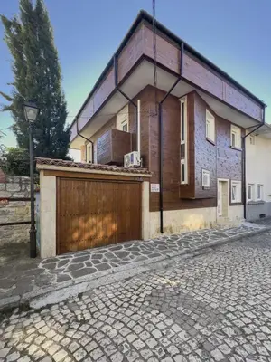 a house with a wooden fence and a garage at Villa Alenor | Sea View & Beach Access in Nesebar