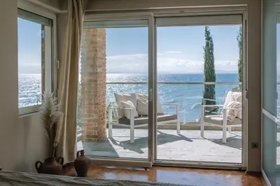 a room with a sliding glass door with a view of the ocean at Villa Alenor | Sea View & Beach Access in Nesebar