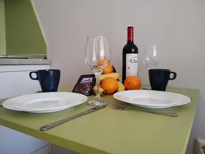 a table with two plates and two wine glasses at Studio Sorrento Sole Mare-Bastet BS in Sveti Vlas