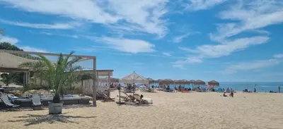 a beach with chairs and umbrellas and people on the beach at Studio Sorrento Sole Mare-Bastet BS in Sveti Vlas