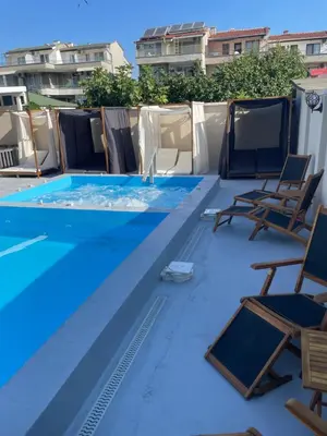 a swimming pool with chairs and a swimming pool at Family Hotel Malibu in Chernomorets