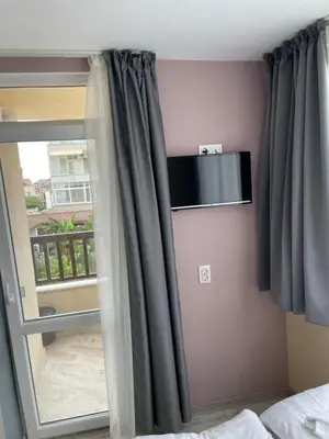 a room with a window and a door with curtains at Family Hotel Malibu in Chernomorets