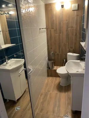 a bathroom with two sinks and a toilet and a shower at Family Hotel Malibu in Chernomorets