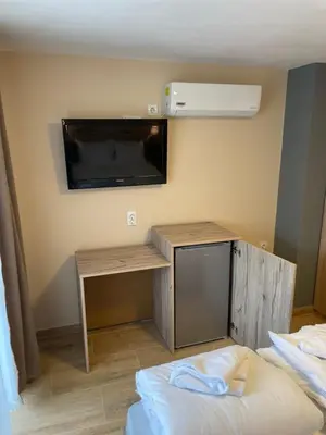 a room with a desk and a tv on the wall at Family Hotel Malibu in Chernomorets