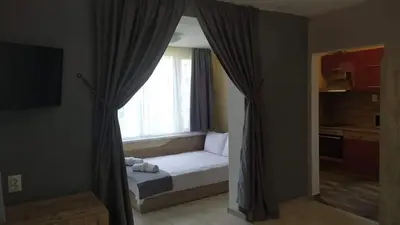 a small bedroom with a bed and a window at Family Hotel Malibu in Chernomorets
