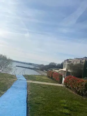 a walkway leading down to a river with buildings and flowers at Pomorie Direkt am Pool in Pomorie
