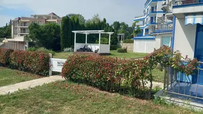 a fence with a horse statue next to a house at Pomorie Direkt am Pool in Pomorie