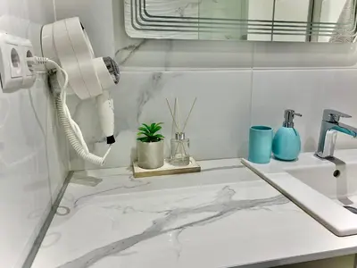 a white bathroom with a sink and a phone at AVRORA in Varna City