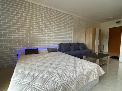a bedroom with a bed and a brick wall at Sveti Vlas Modern Studio with Pool & Balcony by Flat Mаnаger in Sveti Vlas