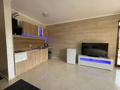 a large kitchen with a large flat screen tv at Sveti Vlas Modern Studio with Pool & Balcony by Flat Mаnаger in Sveti Vlas
