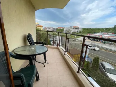 a balcony with a table and chairs and a view of a highway at Sveti Vlas Modern Studio with Pool & Balcony by Flat Mаnаger in Sveti Vlas