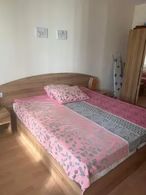 a bed with a pink comforter on top of it at Fort Noks - Marina View in Sveti Vlas