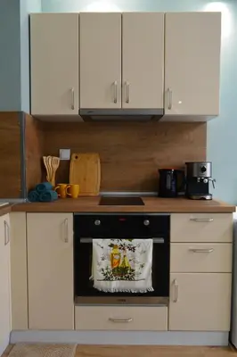 a kitchen with white cabinets and an oven at City Center Apartment in Burgas City