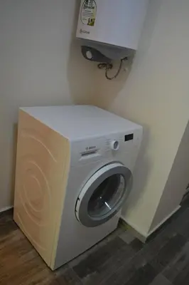 a washing machine in the corner of a room at City Center Apartment with a Backyard in Burgas City