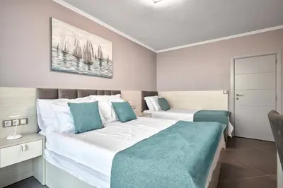 a bedroom with a large white bed with blue pillows at 3BD Beach Paradise with a Stunning View with Parking by Flat Mаnаger in Nesebar