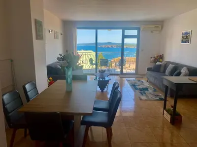 a living room with a table and chairs and a couch at Gorgeous, 1 Bed Apt, Sea Views. in Duni