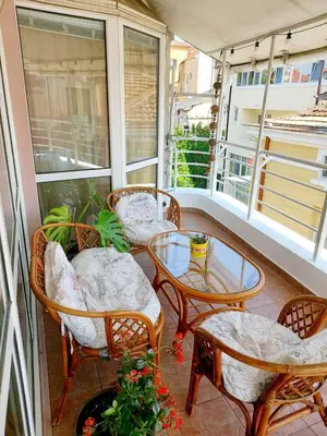 a porch with chairs and a table on a balcony at Comfort Flat in Burgas City
