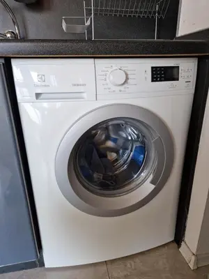 a white washing machine with a black counter top at Comfort Flat in Burgas City