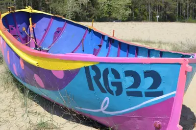 a colorful boat sitting on the sand on a beach at Апартамент в Oasis Beach Kamchia -THE FAVOURITE BLUE in Bliznatsi