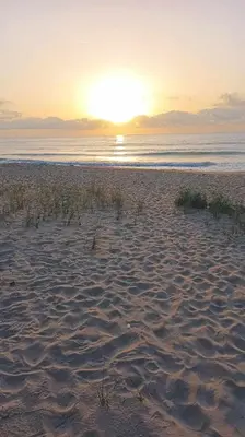 a beach with the sun setting over the water at Апартамент в Oasis Beach Kamchia -THE FAVOURITE BLUE in Bliznatsi
