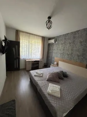 a bedroom with a large bed and a desk at Alagen Apartments Burgas in Burgas City