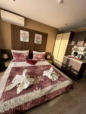 a bedroom with a bed with two white shoes on it at Sea View Private Studio Paradiso B 509 in Nesebar