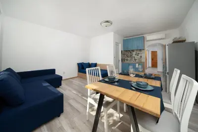 a living room with a table and a blue couch at Boutique Blue Apartment in Sveti Vlas