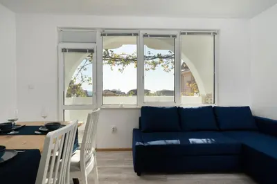 a living room with a blue couch and a table at Boutique Blue Apartment in Sveti Vlas