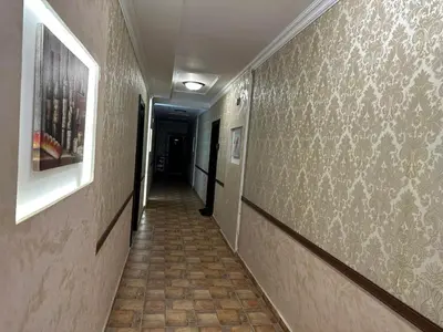 a hallway with a tile floor and a wall with paintings at MARINA Apartments in Ravda