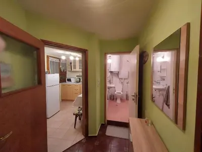 a kitchen with green walls and a bathroom with a toilet at Surf house in Burgas City