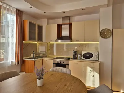 a kitchen with a wooden table and a dining room at Garden of Eden - Apartament Niya in Sveti Vlas