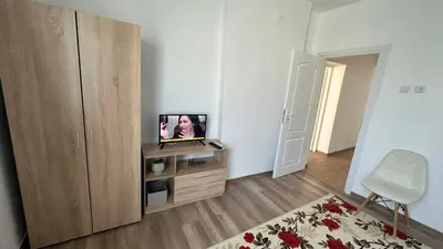 a living room with a television on a wooden cabinet at Apartment ADELINA in Tsarevo