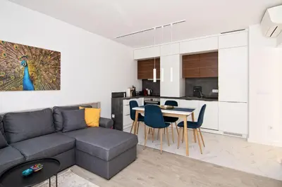 a living room and kitchen with a couch and a table at Greek quarter flat two BR next to Sea Garden in Varna City