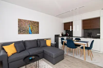 a living room with a couch and a table with chairs at Greek quarter flat two BR next to Sea Garden in Varna City