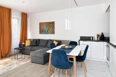 a living room with a couch and a table and chairs at Greek quarter flat two BR next to Sea Garden in Varna City