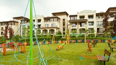 a playground in a park in front of a building at Green Line Apartament Sozopol in Sozopol