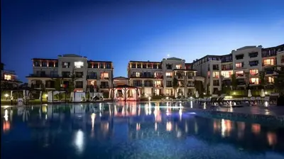 a large swimming pool in front of buildings at night at Green Line Apartament Sozopol in Sozopol