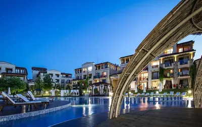 a bridge over a pool in a city at night at Green Line Apartament Sozopol in Sozopol
