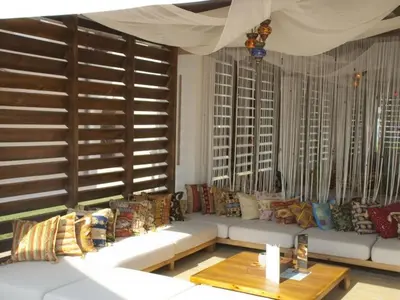 a living room with a white couch and windows at Green Line Apartament Sozopol in Sozopol