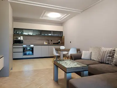 a living room with a couch and a table at Green Line Apartament Sozopol in Sozopol