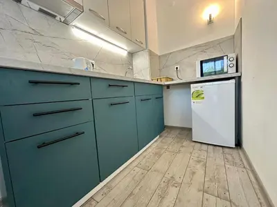 a kitchen with blue cabinets and a white refrigerator at Chateau Aheloy 2 - Menada Apartments in Aheloy