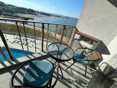 a balcony with a table and chairs and the beach at Sea View Private Studio B 511 in Nesebar