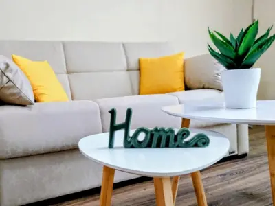 a living room with two tables with the word home written on them at Ika apartment in Burgas City