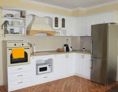 a kitchen with white cabinets and a stainless steel refrigerator at Ika apartment in Burgas City