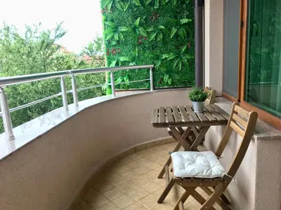 a balcony with a table and two chairs and a window at Ika apartment in Burgas City