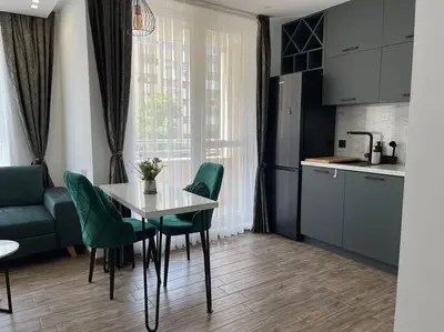 a kitchen with a table and green chairs in a room at Studio Green Зелено Студио in Burgas City