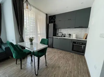 a kitchen with a table and green chairs in a room at Studio Green Зелено Студио in Burgas City
